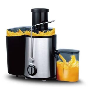 Electric centrifugal juicer with a stainless steel body and black accents, pouring fresh orange juice into a carafe.